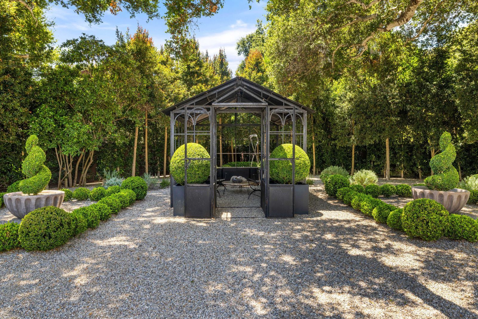 A striking Victorian-style glass pavilion in a well manicured garden